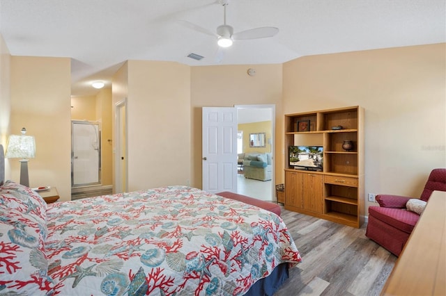 bedroom with a ceiling fan, light wood-type flooring, visible vents, and vaulted ceiling