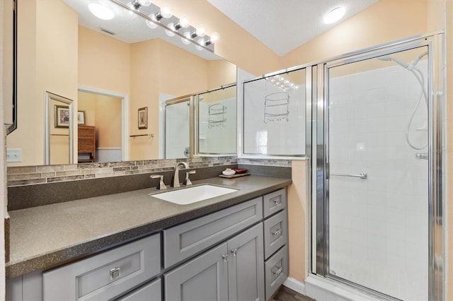 full bath featuring lofted ceiling, a stall shower, vanity, and decorative backsplash