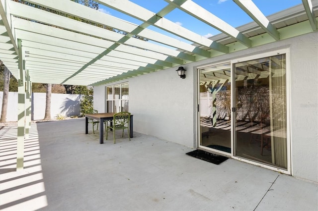 view of patio featuring outdoor dining area, fence, and a pergola