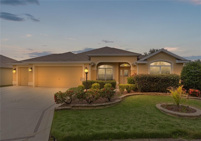 view of front of property with a garage and a lawn