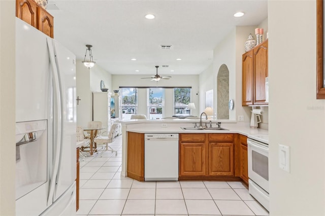 5135 Aurora Dr, Leesburg, FL 34748 - kitchen featuring light tile patterned floors, a peninsula, white appliances, a sink, and light countertops