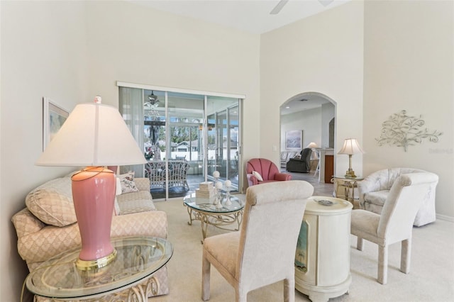 5135 Aurora Dr, Leesburg, FL 34748 - living room featuring arched walkways, ceiling fan, a high ceiling, and carpet flooring