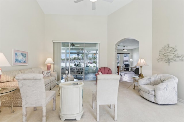 5135 Aurora Dr, Leesburg, FL 34748 - living room with arched walkways, ceiling fan, carpet flooring, and a towering ceiling
