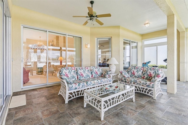 5135 Aurora Dr, Leesburg, FL 34748 - living area featuring ceiling fan with notable chandelier and stone finish flooring