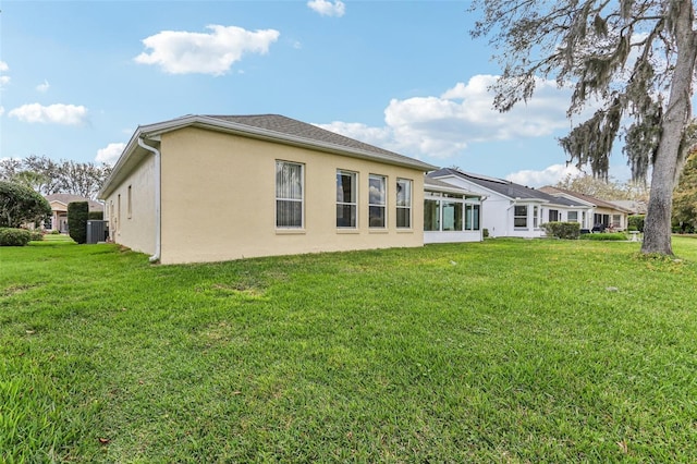 5135 Aurora Dr, Leesburg, FL 34748 - rear view of property featuring a lawn, cooling unit, and stucco siding
