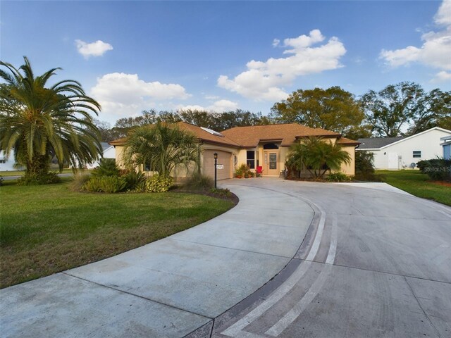 view of front of home featuring stucco siding, an attached garage, concrete driveway, and a front yard