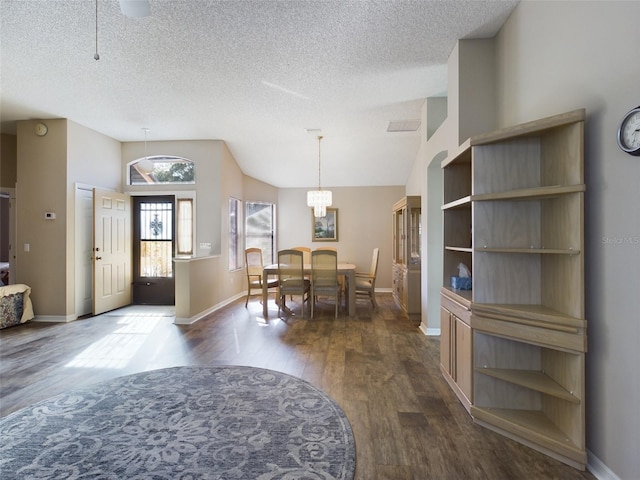 dining room featuring dark wood-style floors, a textured ceiling, and baseboards