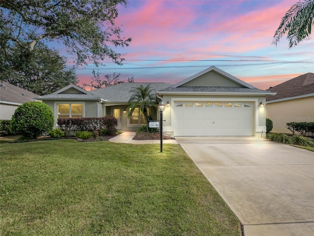 ranch-style house with concrete driveway, a front lawn, and stucco siding