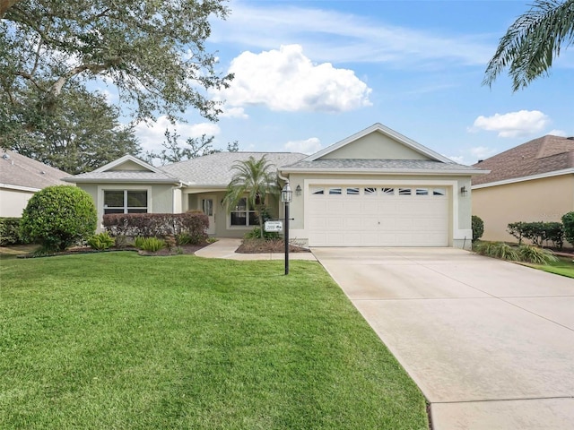 single story home featuring a garage, driveway, a front yard, and stucco siding