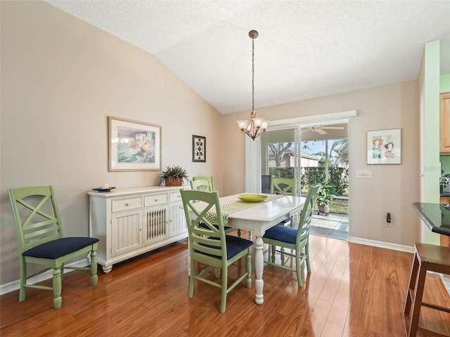 dining area with lofted ceiling, a textured ceiling, light wood-style flooring, and baseboards