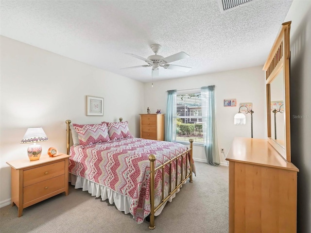 bedroom featuring a ceiling fan, light carpet, a textured ceiling, and baseboards