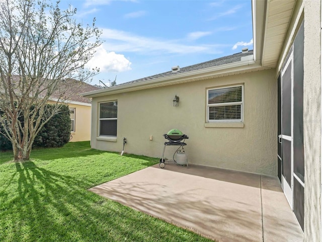 exterior space with a patio, a lawn, and stucco siding