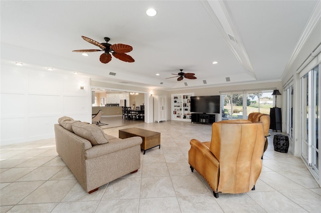 living room with a tray ceiling, light tile patterned flooring, ornamental molding, and ceiling fan