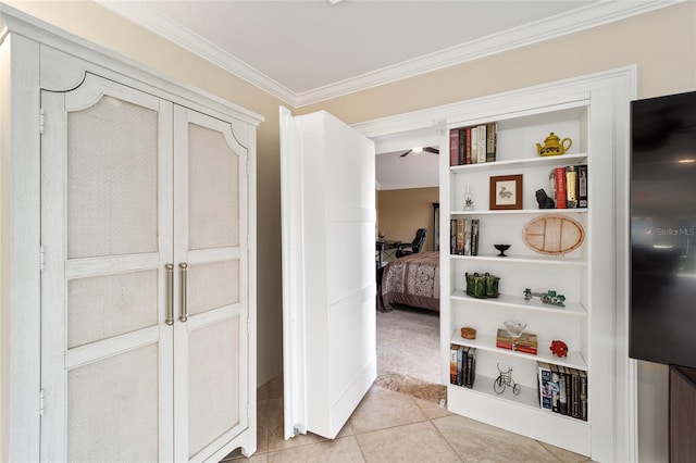 interior space with built in features, ornamental molding, and light tile patterned floors