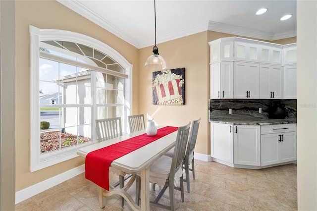 dining space featuring plenty of natural light, baseboards, and ornamental molding