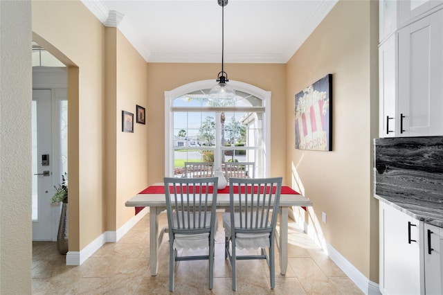 dining space with arched walkways, baseboards, ornamental molding, and light tile patterned floors