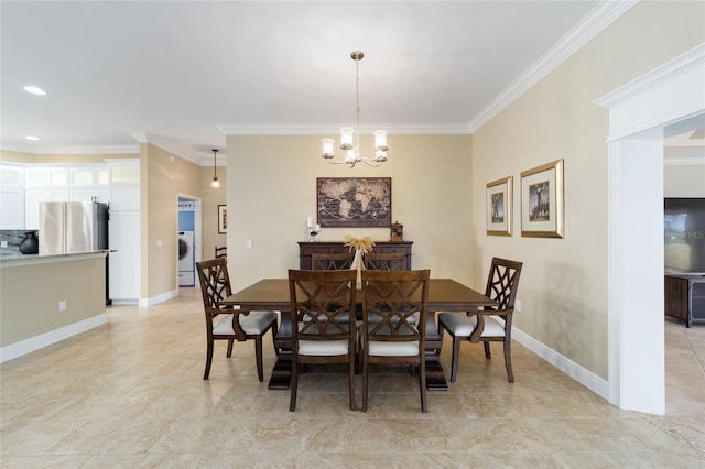dining room featuring baseboards, a notable chandelier, ornamental molding, and washer / clothes dryer