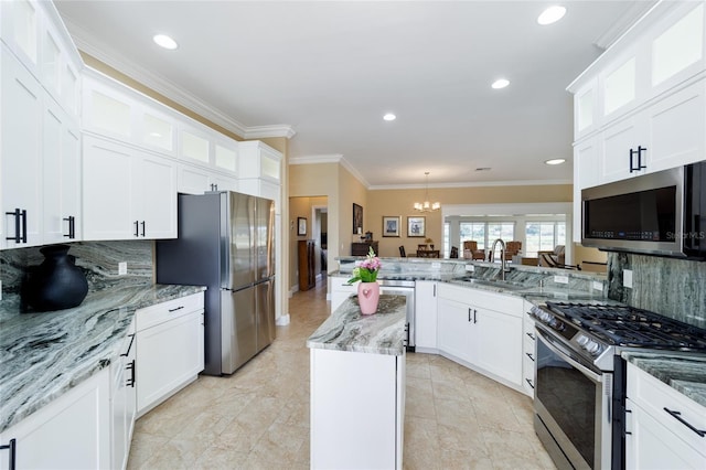kitchen featuring a sink, white cabinetry, backsplash, a peninsula, and appliances with stainless steel finishes