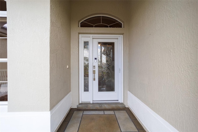 view of exterior entry featuring stucco siding