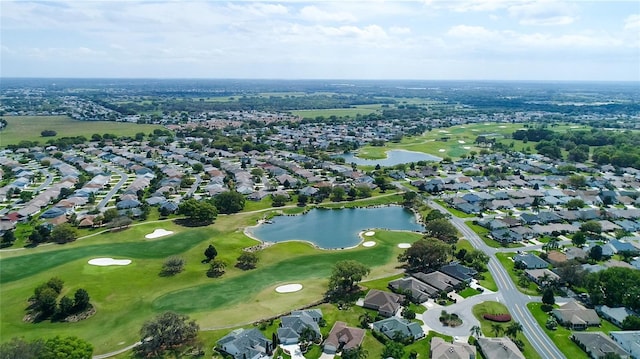 drone / aerial view with view of golf course, a residential view, and a water view
