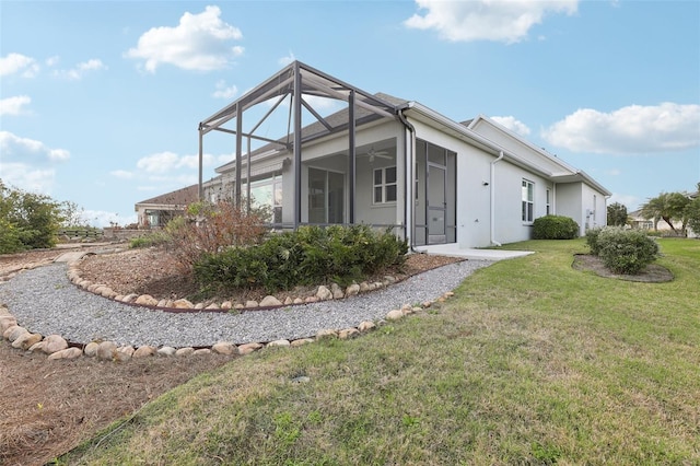 960 Pickering Path, The Villages, FL 32163 - rear view of property with a lawn, glass enclosure, ceiling fan, and stucco siding