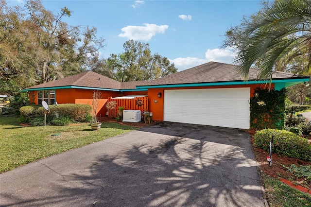 ranch-style home with a front lawn and a garage