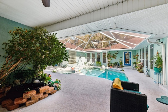 view of pool featuring an in ground hot tub, glass enclosure, and a patio area