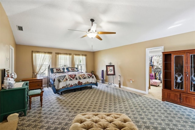 bedroom featuring lofted ceiling, ceiling fan, light carpet, and a spacious closet