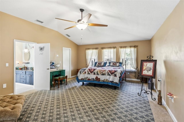 bedroom featuring vaulted ceiling, light colored carpet, ceiling fan, and ensuite bath