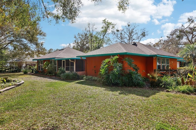 back of property featuring a yard and a sunroom