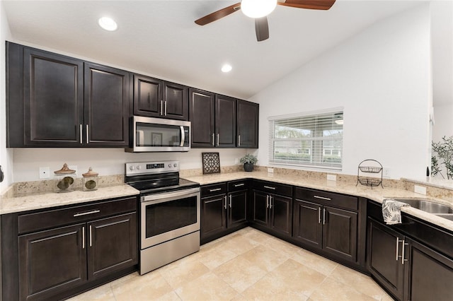 kitchen featuring recessed lighting, stainless steel appliances, a sink, vaulted ceiling, and light stone countertops