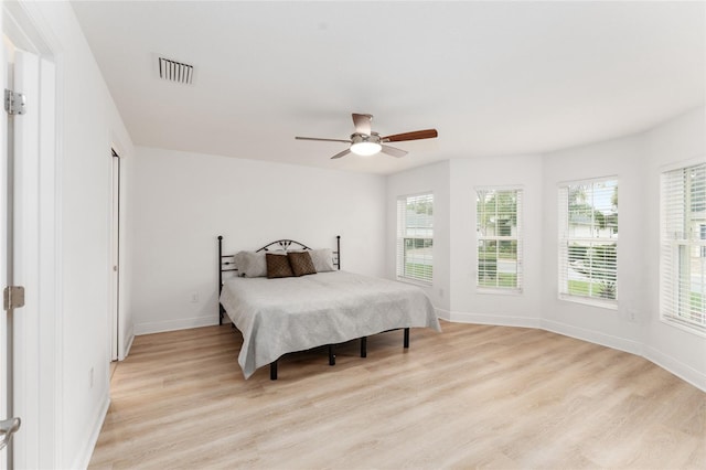 bedroom with light wood-style flooring, visible vents, and baseboards