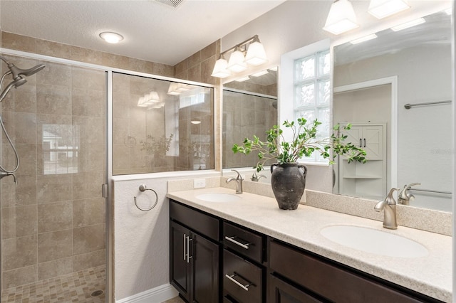 bathroom with double vanity, a stall shower, and a sink