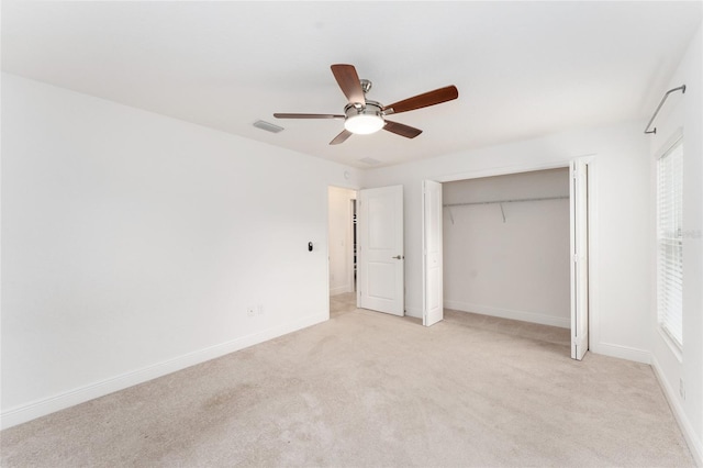 unfurnished bedroom with baseboards, ceiling fan, visible vents, and light colored carpet