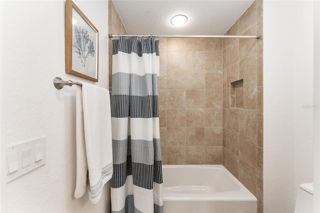 full bath with a textured ceiling, shower / tub combo, and toilet