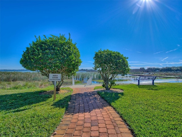 view of home's community featuring a water view, a patio, and a yard