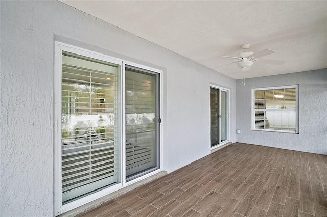 unfurnished sunroom featuring ceiling fan