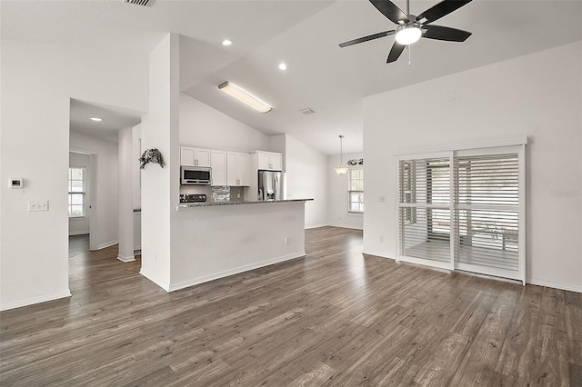 kitchen with kitchen peninsula, white cabinets, stainless steel appliances, and dark hardwood / wood-style floors