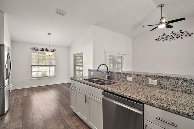 kitchen featuring lofted ceiling, stainless steel appliances, sink, white cabinets, and stone countertops