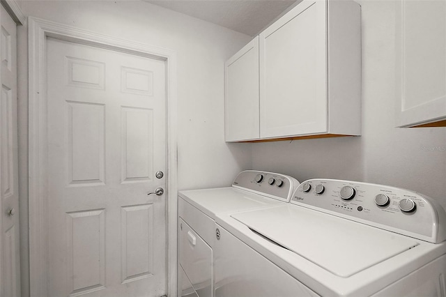 laundry area with washer and clothes dryer and cabinets