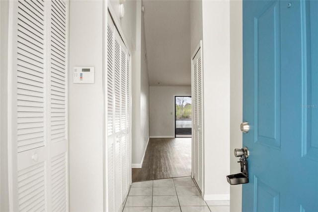 hallway with baseboards and light tile patterned flooring