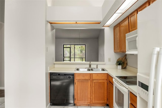 kitchen featuring brown cabinetry, white appliances, light countertops, and a sink