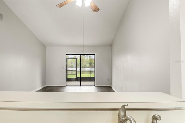 empty room with baseboards, a ceiling fan, and wood finished floors