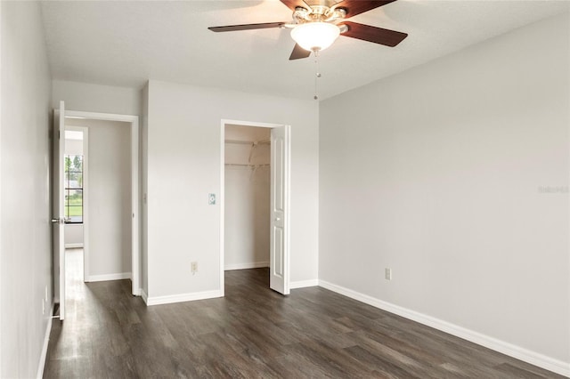 unfurnished bedroom featuring dark wood-style floors, a ceiling fan, baseboards, and a closet