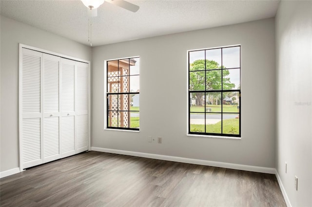 unfurnished bedroom featuring a closet, baseboards, and wood finished floors