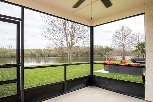 unfurnished sunroom with a ceiling fan and a water view