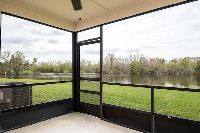 unfurnished sunroom featuring ceiling fan and a water view