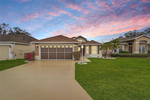 view of front of house featuring a garage, a front yard, concrete driveway, and stucco siding