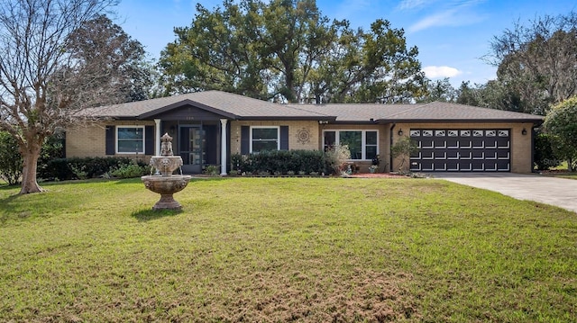 single story home with a front yard, brick siding, driveway, and an attached garage