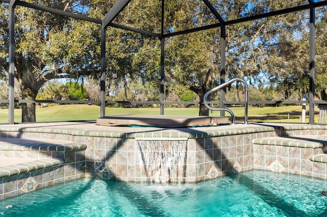 view of swimming pool with glass enclosure, a hot tub, and pool water feature